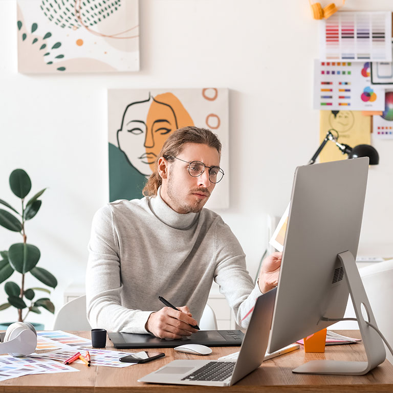 man with glasses designing on computer
