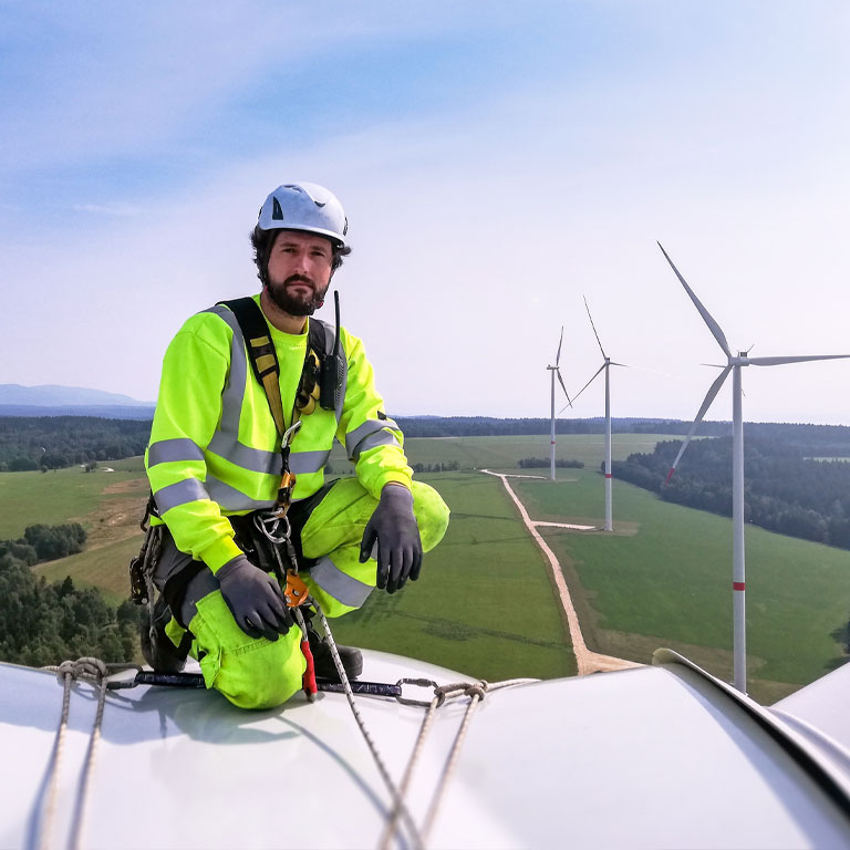 man on wind turbine carrying out maintenance 