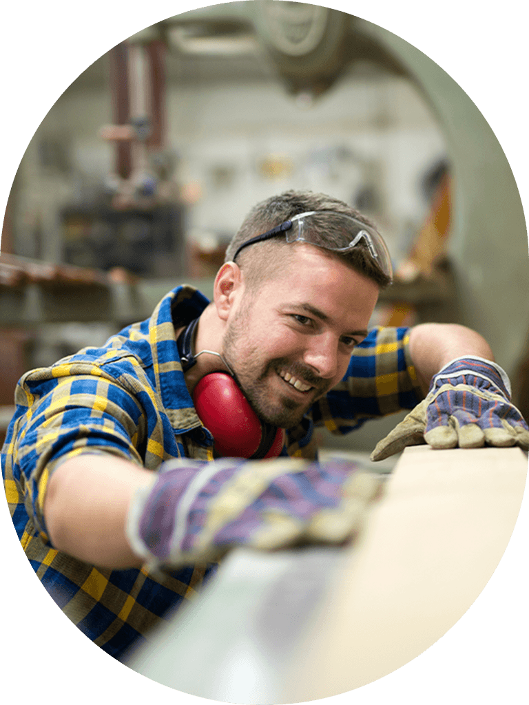 Carpenter man looking down a plank of wood