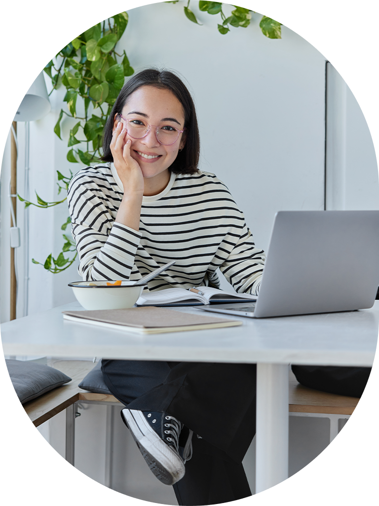 woman at desk with laptop and notepad